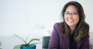 women at desk wearing glasses